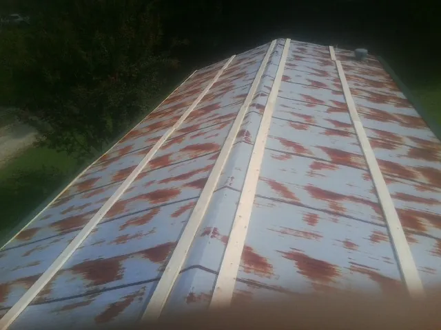 Rusted metal roof panels with new wood purlins before replacement — Storm Damage Roof Repair in Weed by Roofing Brothers