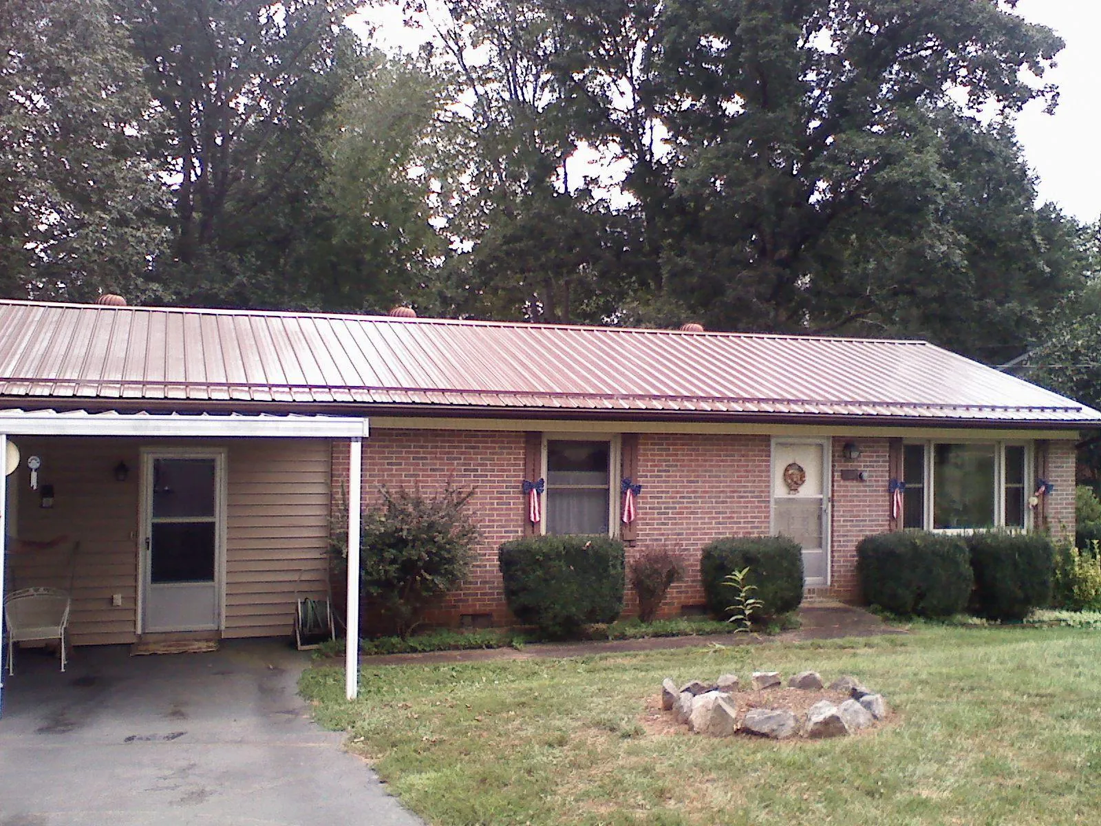 Bronze metal roof and carport on a brick ranch home — Roof Repair work by our crew in Weed